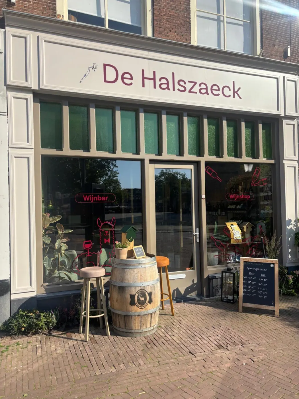De gevel van De Halszaeck aan de Markt in Gouda, met een wijnton en krukken voor de deur